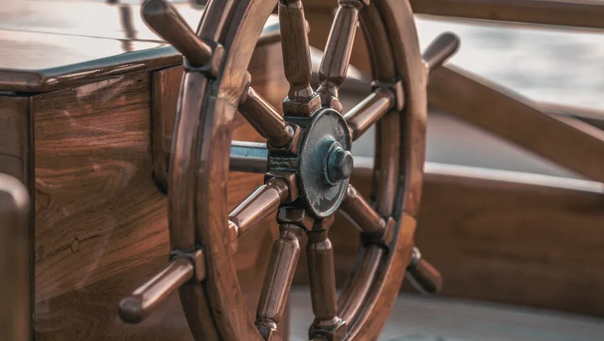Barre à roue en bois verni sur le pont d’un voilier